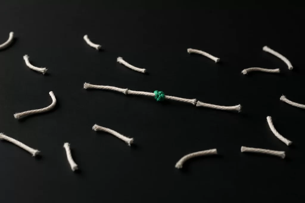 Pieces of cut thread, a few tied back together with a green knot