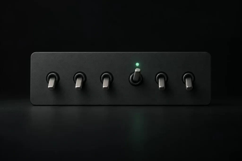 A panel of toggle switches, all down except one lit green